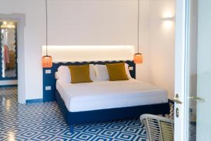 ein Schlafzimmer mit einem großen Bett mit gelben Kissen in der Unterkunft o' mar - Amalfi Coast Suite in Praiano