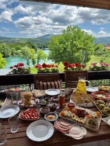 a table full of food with a view of a river at Resting House Oaza in Bihać