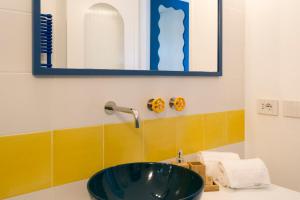 a bathroom with a green sink and a mirror at o' mar - Amalfi Coast Suite in Praiano