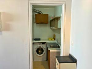 eine Küche mit Waschmaschine und Spüle in der Unterkunft Studio with Panoramic View: Live in Peace! in Paris
