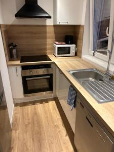 a small kitchen with a sink and a microwave at Appartement Armentières proche gare in Armentières