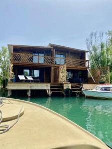 ein Haus auf einer Anlegestelle auf dem Wasser mit einem Boot in der Unterkunft Meris in Ulcinj