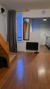 ein Wohnzimmer mit Flachbildfernseher und Holzboden in der Unterkunft Joli 2 pièces - du centre de Paris 12 minutes in Les Lilas + 7 Fotos