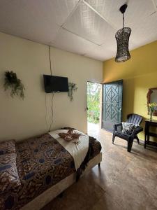 um quarto com uma cama, uma televisão e uma cadeira em Villa Castillo de Ensueño em Concepción de Ataco