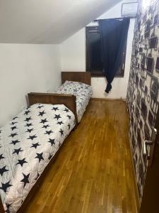1 dormitorio con 2 camas y suelo de madera en House in Center en Skopie