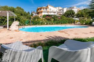 - une piscine avec 2 chaises en face d'une maison dans l'établissement Villa Agnese, à Badesi