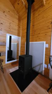 a fireplace in a log cabin with a mirror at Valle Das Águas in Urubici