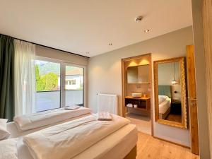 ein Hotelzimmer mit 2 Betten und einem Spiegel in der Unterkunft Art Residence Josefshof in Algund