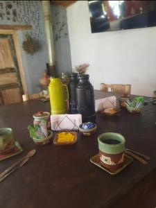 a table with bowls and cups and utensils on it at Posta Kamak Eco Posada Rural in Bella Vista