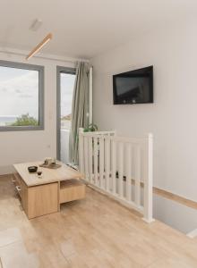 ein Wohnzimmer mit einem Tisch und einem TV an der Wand in der Unterkunft Cozy Residence in Astypalea-Stadt