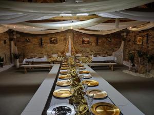 einen langen Tisch mit Tellern und Weingläsern in der Unterkunft Dolistówka in Goniądz