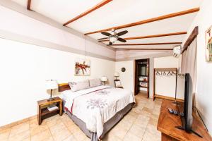a bedroom with a bed and a flat screen tv at Xalli Beach Hotel in Altagracia