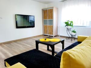 Dom na Błękitnej في كارفينسكي بلوتو بيرافيزا: غرفة معيشة مع أريكة صفراء وطاولة قهوة
