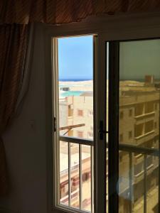 ein offenes Fenster mit Blick auf ein Gebäude in der Unterkunft bianco Hotel & Suites in Marsa Matruh