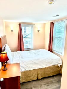 a bedroom with a bed and two windows at Atlantic Breeze Motel & Apartments in Ocean City