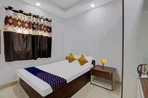 ein weißes Zimmer mit einem Bett und einem Tisch in der Unterkunft OYO Zois Nest in Kammasandra