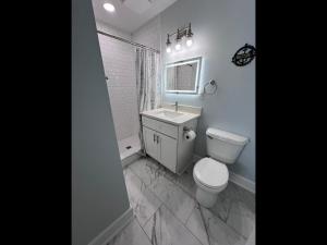 a white bathroom with a toilet and a sink at Boston Commons Penthouse Condo in Myrtle Beach