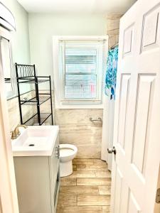 uma casa de banho com um WC, um lavatório e uma janela em Bill's Apartments em Ocean City