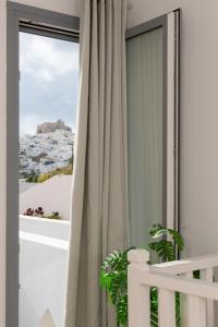 a room with a window with a white curtain at Cozy Residence in Astypalaia Town