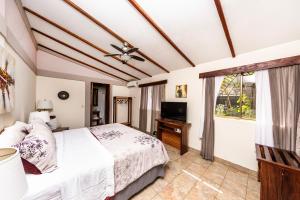 1 dormitorio con 1 cama y TV en Xalli Beach Hotel en Altagracia