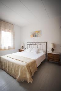 una camera bianca con un grande letto e una finestra di El Solell de l'àvia a Olot
