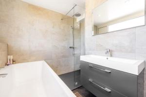 Baño blanco con lavabo y espejo en Ramsey Guesthouse IOM en Ramsey