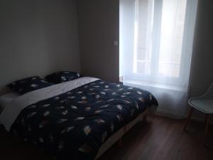 a bed in a room with a window and a bedspread at Appartement F2 neuf in Jarville-la-Malgrange