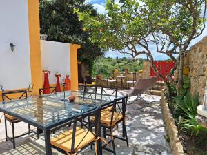 a table and chairs on a patio with a view at Casa das Janelinhas - Cottage near Sintra, Mafra, Ericeira in Mafra