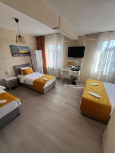 a hotel room with two beds and a desk at Maça Home in Edirne