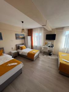 a hotel room with two beds and a desk at Maça Home in Edirne