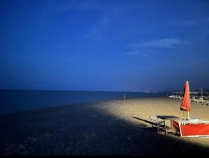 una spiaggia con due sedie e un ombrellone e l'oceano di Aurora Bed and Breakfast a Cirò Marina