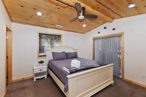 ビッグ・ベア・シティにあるStylish Elysian Big Bear Cabin w Enclosed backyardのベッドと天井扇風機のある寝室