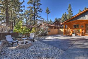 ビッグ・ベア・シティにあるStylish Elysian Big Bear Cabin w Enclosed backyardの裏庭(椅子2脚、テーブル1台、家屋1軒付)