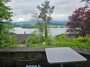 a white table on a stone wall with a view of a lake at Queen Home in Luzern