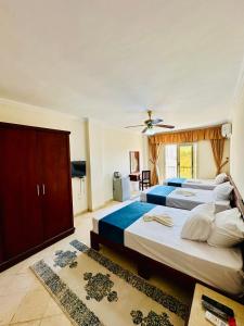 bianco Hotel & Suites في مرسى مطروح: غرفة نوم بسريرين ومروحة سقف