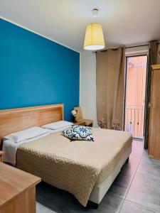 - une chambre avec 2 lits et un mur bleu dans l'établissement Affacciati sulle Eolie Appartamenti sul Lungomare Patti Marina, à Patti