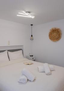 ein Schlafzimmer mit einem weißen Bett mit zwei Handtüchern darauf in der Unterkunft Cozy Residence in Astypalea-Stadt