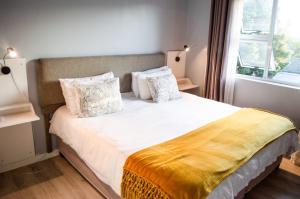 a bedroom with a white bed with a window at Stunning Knysna central Apartment in Knysna