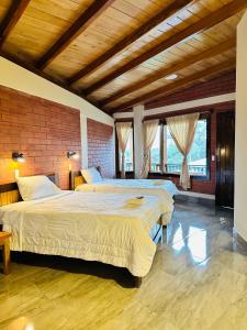 a bedroom with two beds and a brick wall at La Casa de Cecilia Mindo in Mindo