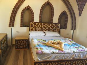 a bedroom with a bed with an arched headboard at Garden view guest house in Luxor