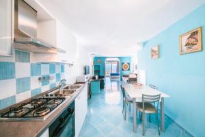 eine blau-weiße Küche mit einem Tisch und Stühlen in der Unterkunft Sea view - Ravello houses in Ravello