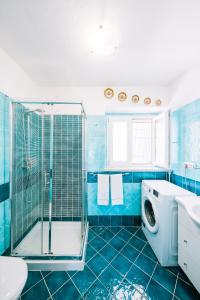La salle de bains bleue est pourvue d'une douche et d'un lave-linge. dans l'établissement Sea view - Ravello houses, à Ravello