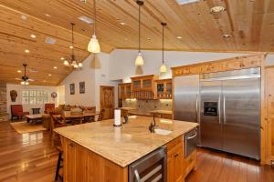 a kitchen with a stainless steel refrigerator and wooden cabinets at Minnow's Big Bear Estate 1.5 Acres W Game Room in Big Bear City