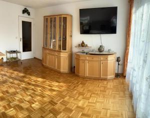 a living room with a wooden floor and a tv at 98, Bergblick, 2 Schlafzimmer, Dusche , WC, Küche, Wohnzimmer in Bad Reichenhall