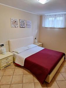 a bedroom with a bed with a red and white blanket at La casa di Charlie in San Giovanni Teatino