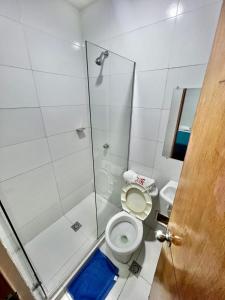 y baño con aseo y ducha acristalada. en Hostal Lumar en Barranquilla