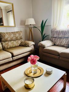a living room with a coffee table with a vase of flowers at EDEN GARDEN b&b in Ponferrada