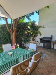 a table and chairs on a patio with a grill at Maison Fruitier with pool at 15m from the Beach in Sainte-Maxime