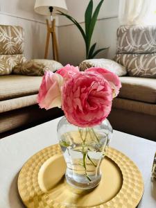 un jarrón con flores rosas sobre una mesa en EDEN GARDEN b&b en Ponferrada
