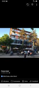 une photo de personnes faisant du vélo devant un bâtiment dans l'établissement Hotel Piazza, à Peshkopi